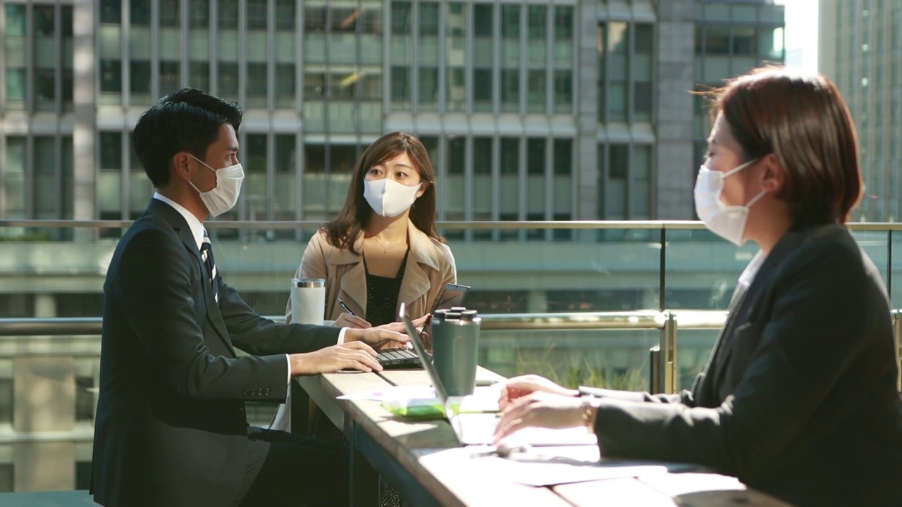 在亚洲，企业人士戴着口罩进行保持社交距离的会议视频下载
