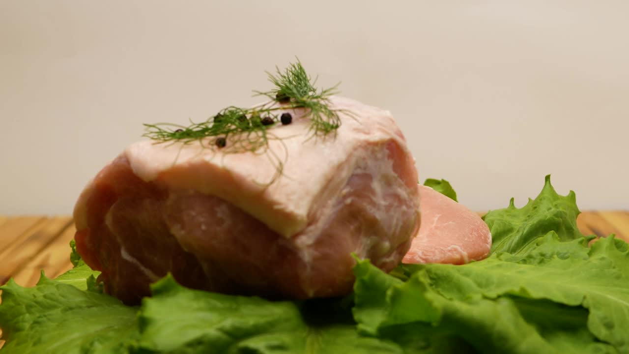 新鲜的生猪肉特写。准备煎。猪肉牛排。旋转。肉放在新鲜的绿色生菜叶子上。特写镜头视频素材