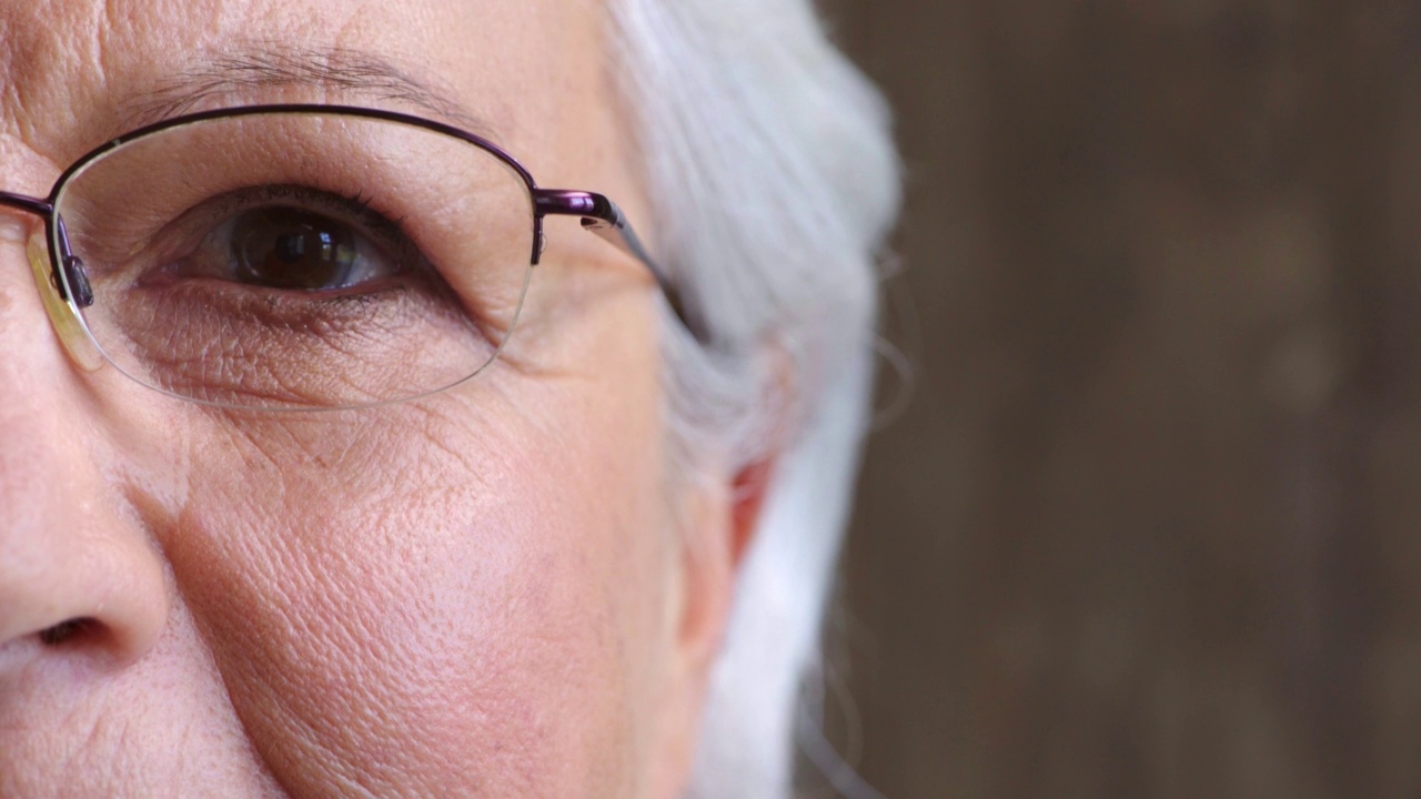 特写肖像的高级妇女的眼睛在验光师。一位退休女性在体检时戴眼镜时的侧面和半张脸。成熟的女士得到新的时髦的眼镜或眼镜视频素材