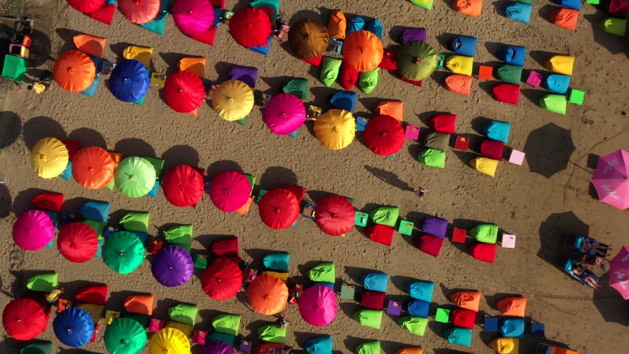空中顶摇拍摄的多色豆袋安排在沙滩上-巴厘岛，印度尼西亚视频素材