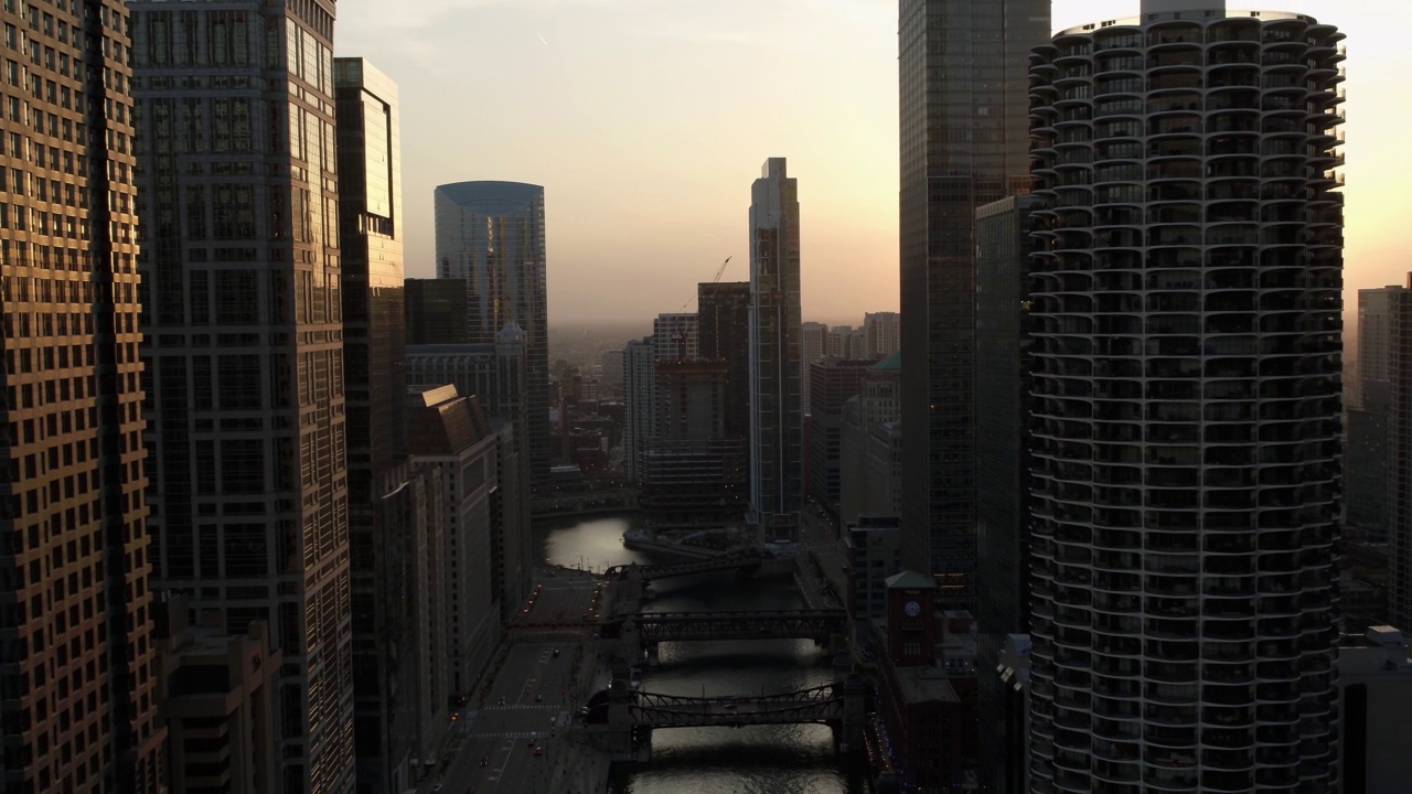 空中拍摄的河流在晴朗的天空下的高楼大厦，无人机在日落时向后飞行-芝加哥，伊利诺伊州视频素材