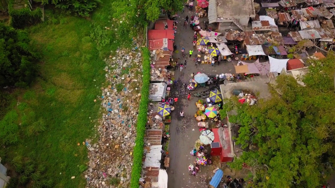 空中向前倾斜拍摄的拥挤的市场在住宅城市-太子港，海地视频下载