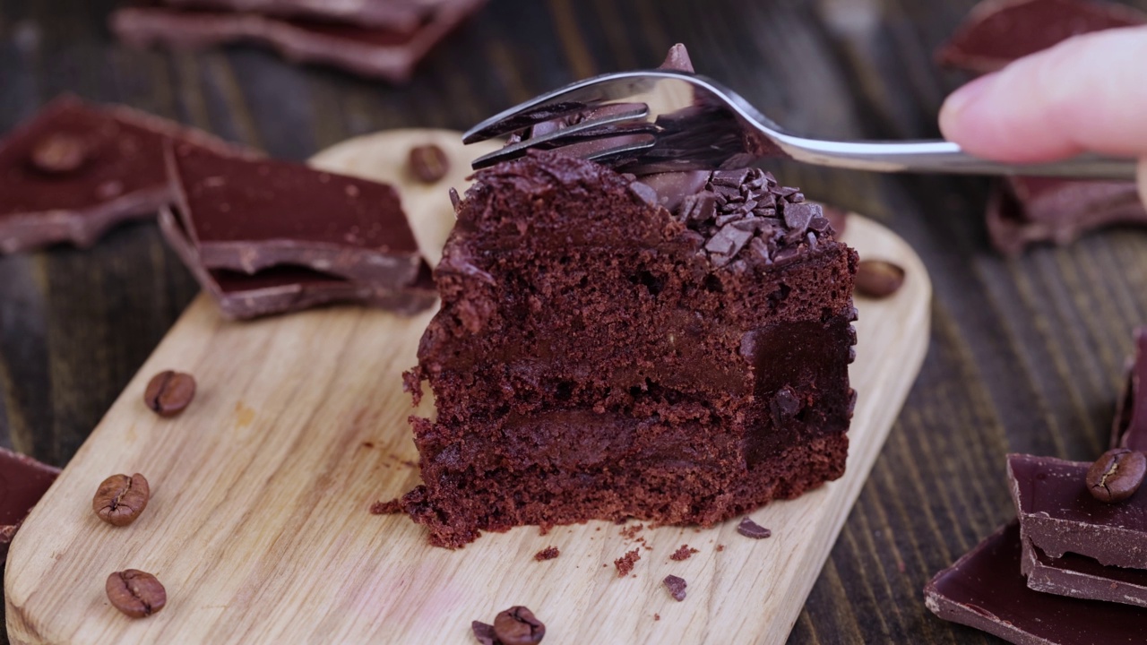 用叉子把一块巧克力馅的巧克力蛋糕分开视频素材