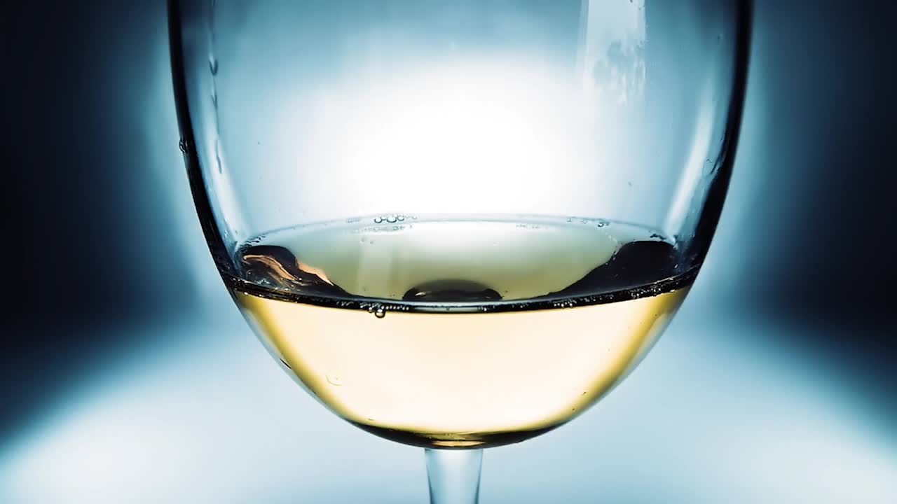 白葡萄酒倒入玻璃杯。玻璃与倒白葡萄酒特写。4k微距慢动作视频。用高速电影摄影机拍摄的。视频素材