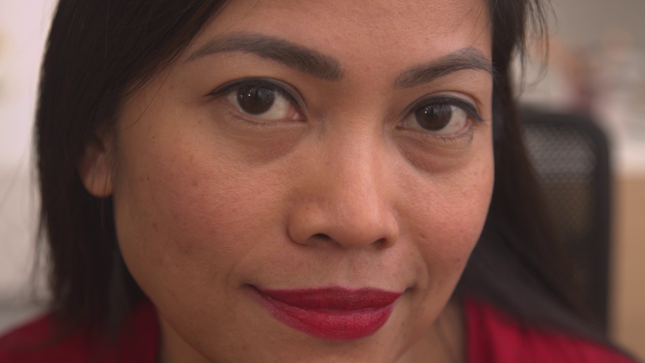 肖像:迷人的菲律宾女人应用生动的红色唇彩到她的嘴唇视频下载