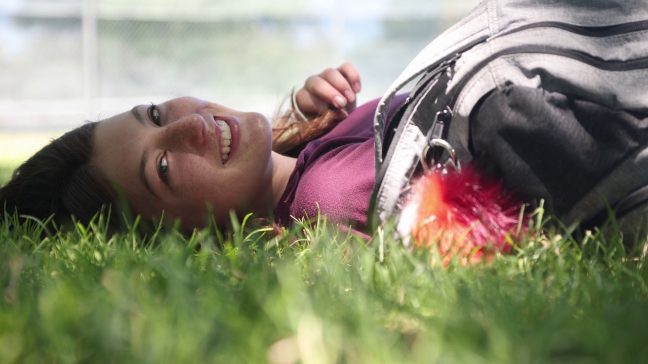 内容十几岁的女性放松，她躺在草地上视频下载