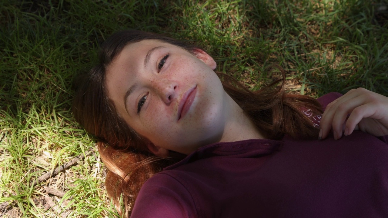 快乐的少女微笑着躺在草地上视频下载