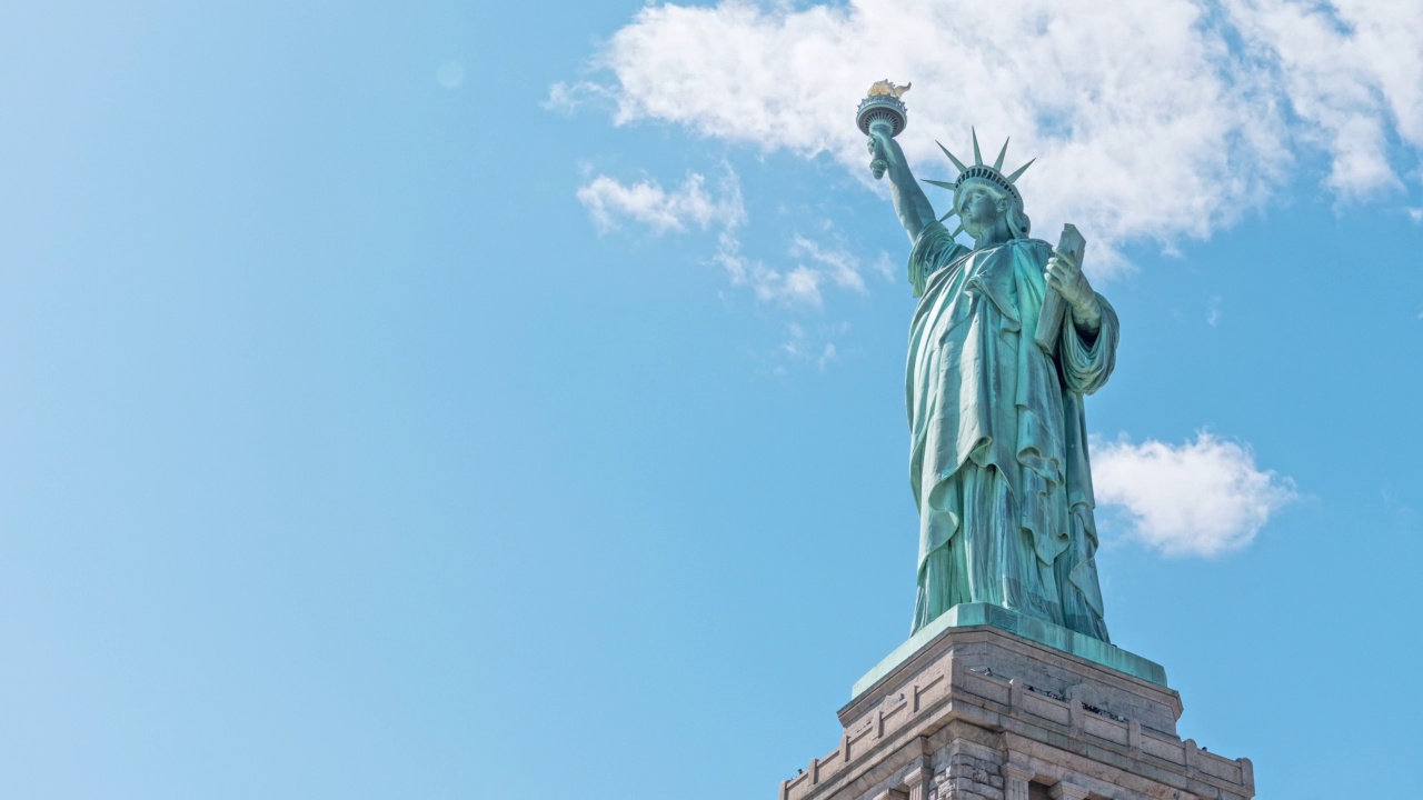 自由女神像纪念碑与时间推移的云在夏天的天空在纽约市，美国。美国旅游景点地标，美国旅游目的地，或国家象征概念视频素材