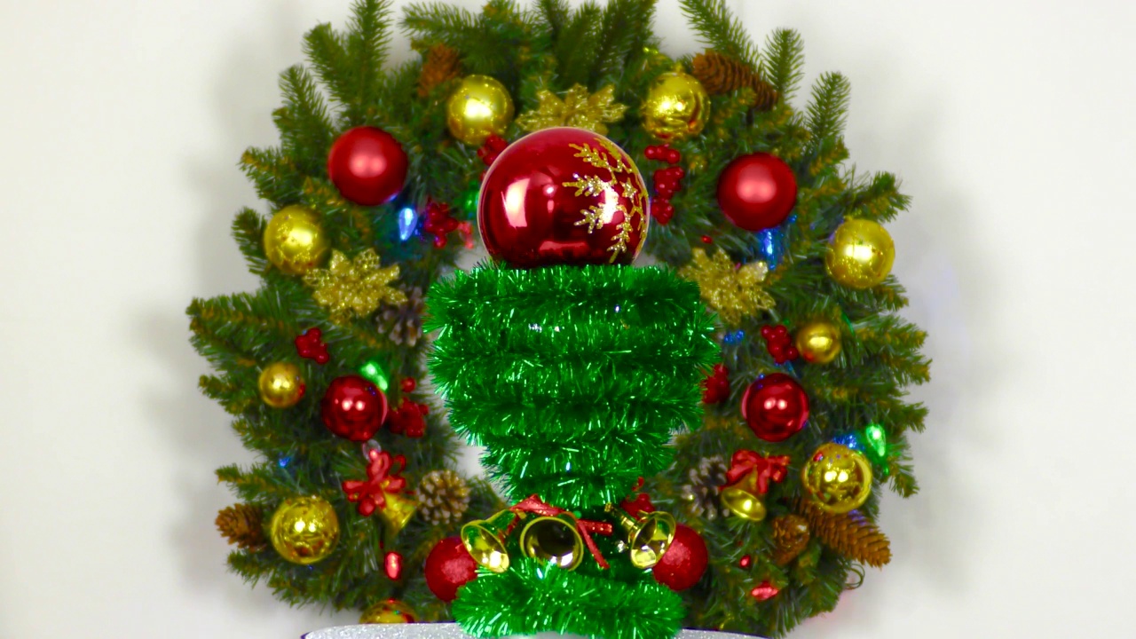 在一个大圣诞花环的背景下，动态的圣诞节。上面有一个红色小球的圣诞小作品正在旋转视频下载
