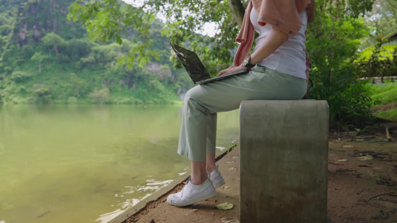 自由程序员，使用笔记本电脑编程的女性在山区旅行时远程工作数字游牧民永恒的旅行者。在周末的旅游中变得被动。视频下载