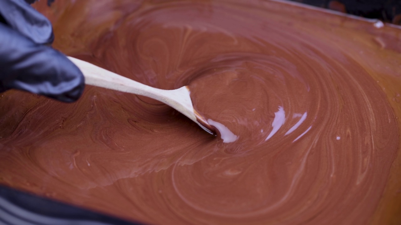 用半勺搅拌融化的巧克力，并在上面滴上巧克力视频素材