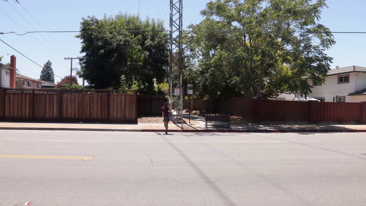 在美国郊区，女青少年跑步穿过街道的后视图视频下载