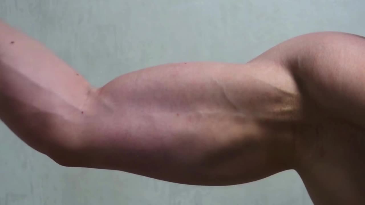 健美运动员弯曲手臂上的二头肌，显示出强壮的肌肉。运动和身体的概念。视频下载