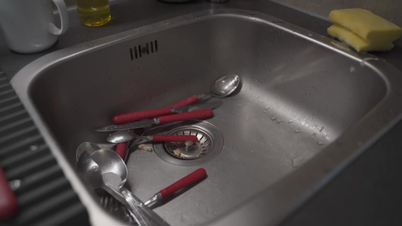 主妇女佣在厨房里洗碗。女人洗碗的双手。用清洁皂清洗盘子。女性用手在厨房的水槽里洗碗。家庭的概念视频素材
