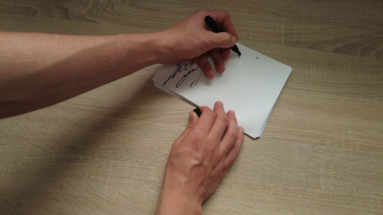 一个左撇子在方格纸上签名视频下载