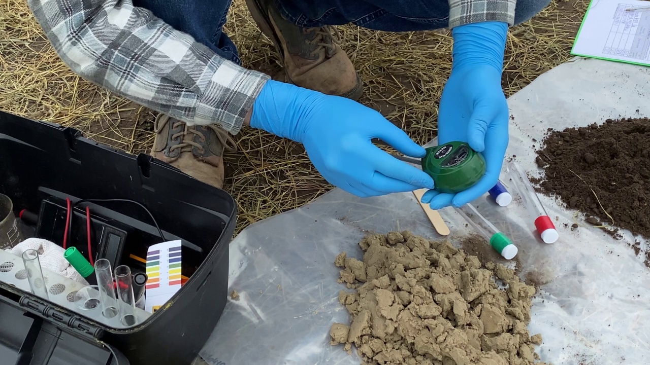 科学家准备用土壤测试仪测量土壤pH值的特写视频素材