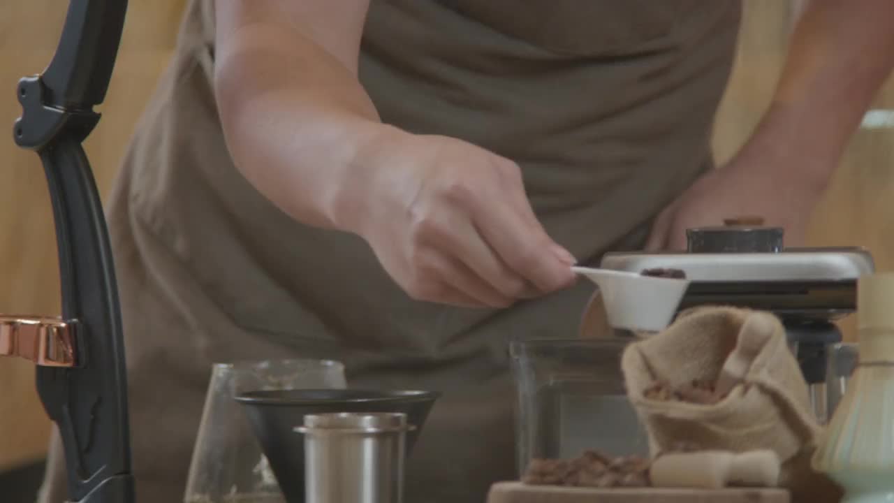 一个年轻人在咖啡、概念咖啡馆和咖啡店的吧台上用咖啡机工作视频素材