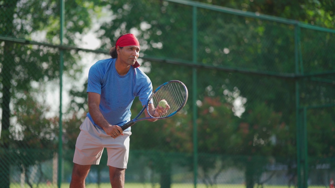 亚洲印度男子网球运动员在网球场上服务视频下载