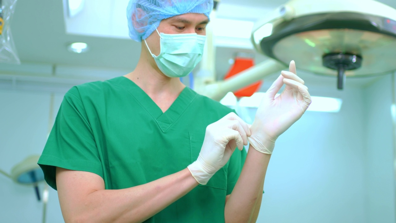 戴着医用手套、戴着医用口罩站在医院手术室的亚洲外科医生肖像。专业外科医生团队。医疗保健、急救医疗服务理念视频下载