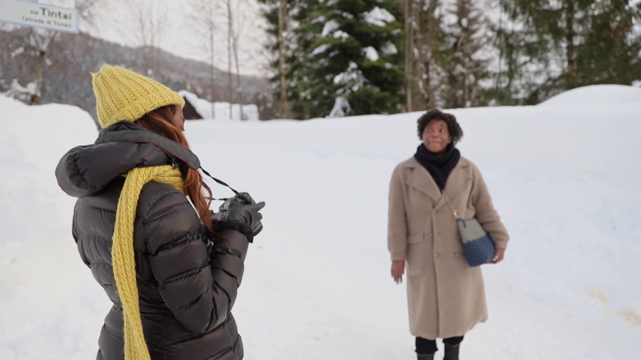 一个摄影师在冬天的山上拍摄一个人的照片，它刚刚下过雪，有很多雪。视频下载