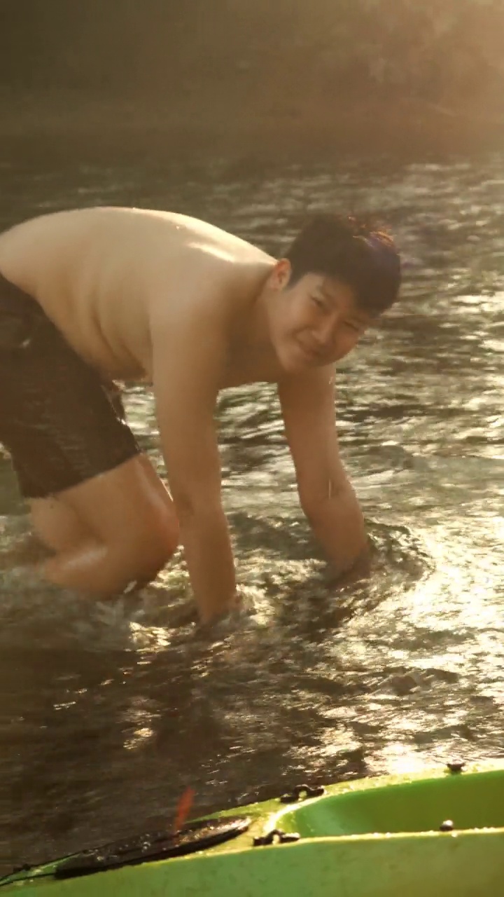 快乐的亚洲男孩在河中放松，户外生活理念。视频素材