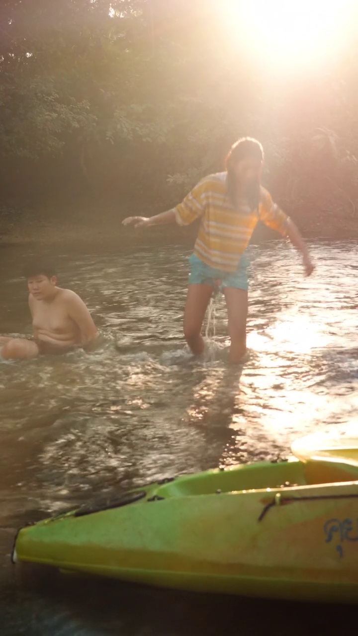快乐的亚洲孩子们一起在阳光下的河流中放松，户外生活理念。视频素材