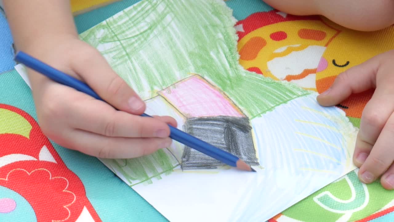 学龄儿童用铅笔蜡笔画画，手的细节，特写。儿童涂色创作活动，艺术和创意概念简单，人的生活方式，一人，慢镜头视频下载
