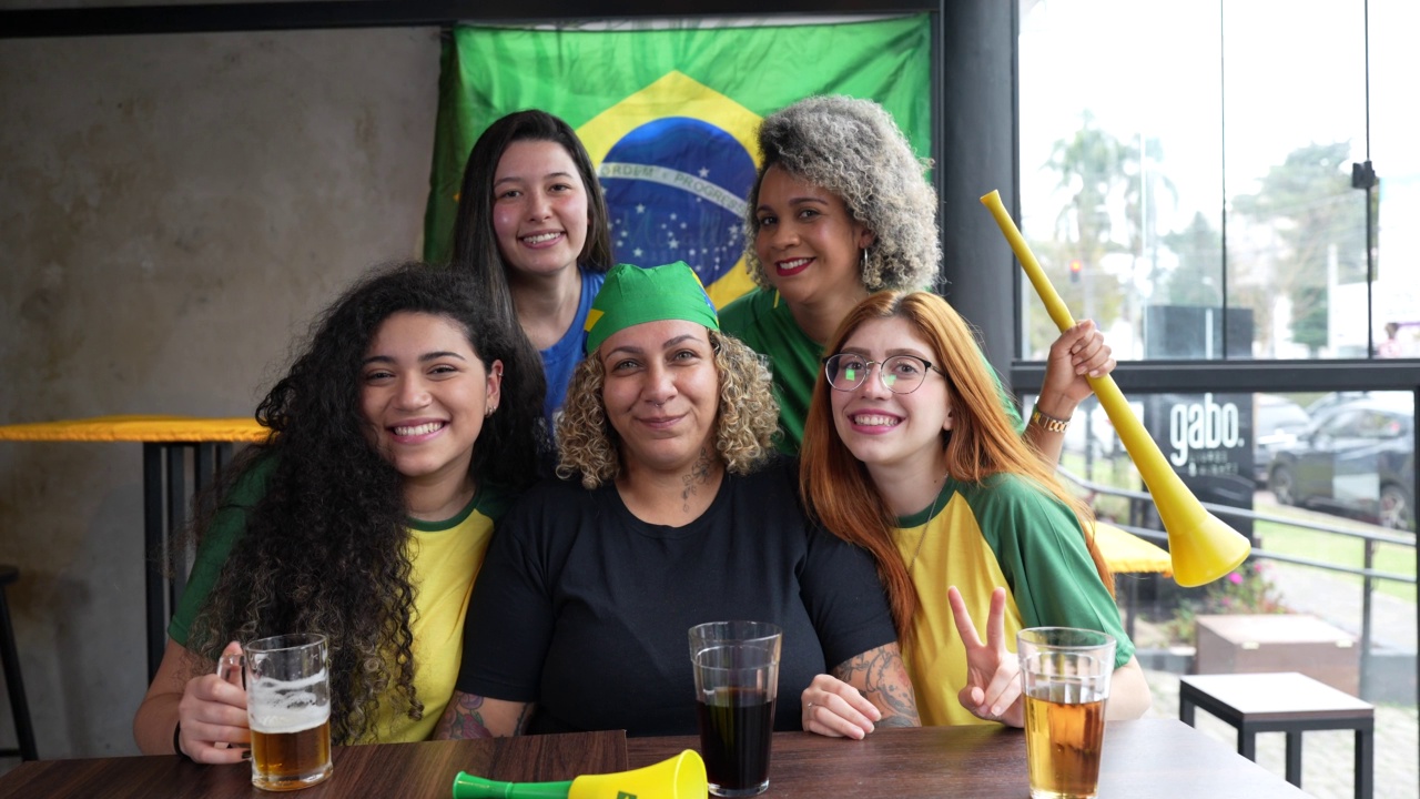 一群微笑的巴西妇女准备观看一场足球比赛视频下载