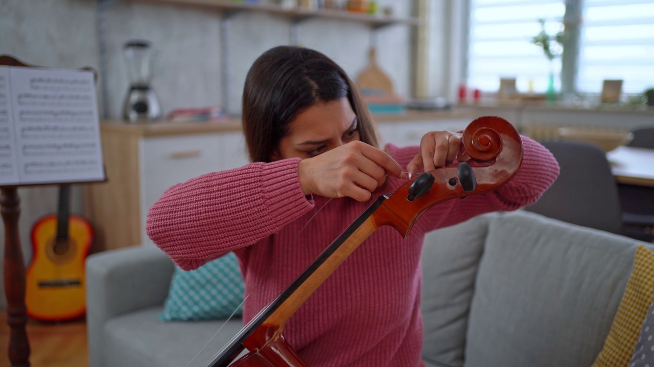 调整大提琴弦的女大提琴手视频下载
