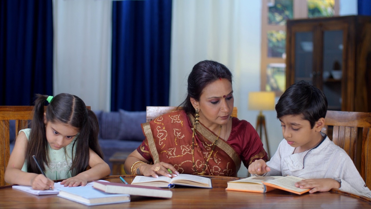 可爱的印度兄弟姐妹在家和妈妈一起做作业/学习——亲子关系，学校作业视频素材