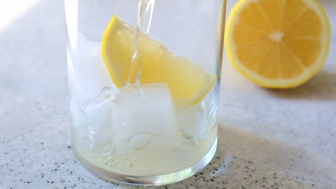 将自制柠檬水倒入加冰的玻璃杯中。视频下载