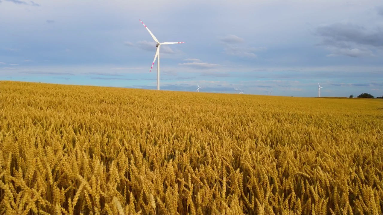 农用风力发电厂的鸟瞰图，美丽的多云天空，背景是大型风力涡轮机视频素材