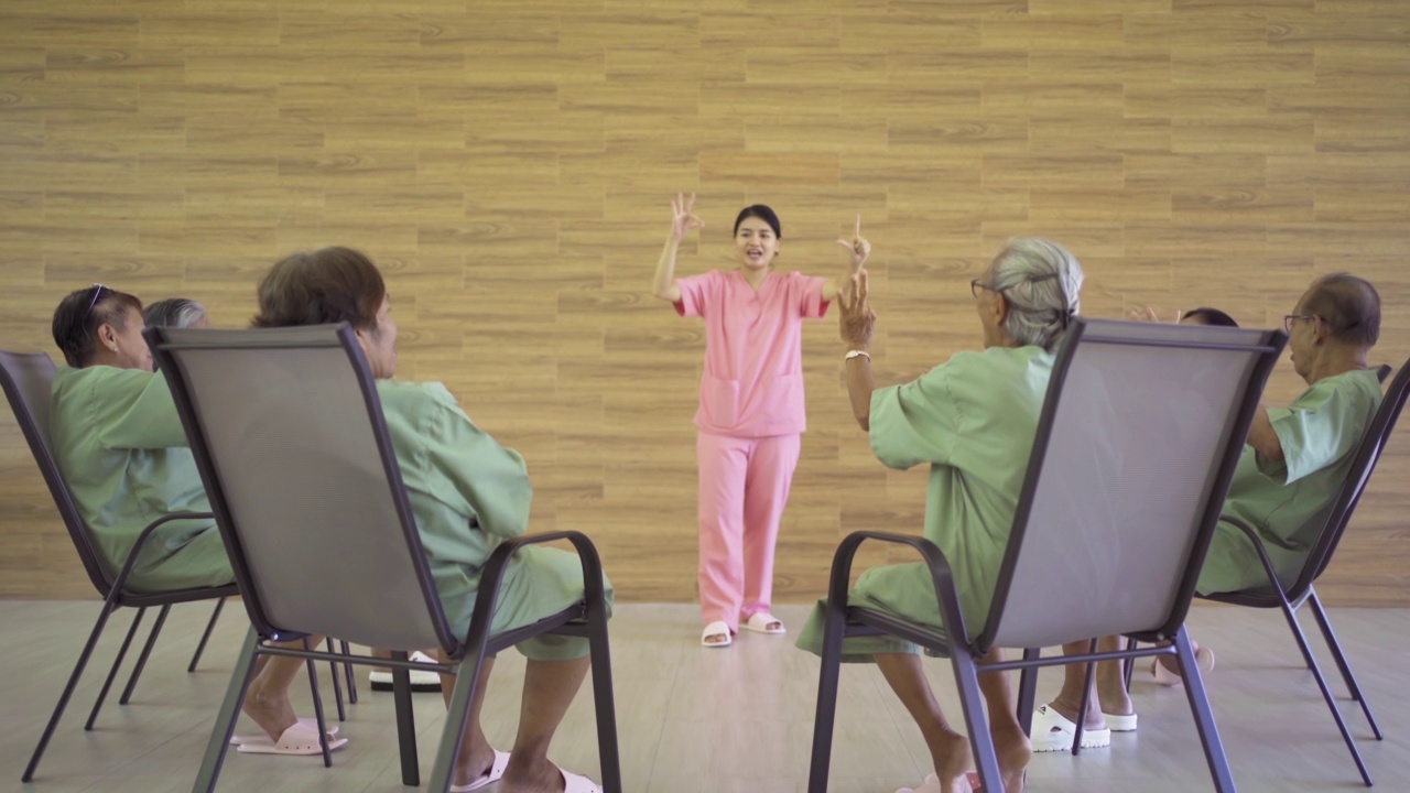 一群快乐的亚洲老人或老人与护士在养老院玩游戏的肖像。老年人生活方式活动娱乐。退休社区。卫生保健视频素材