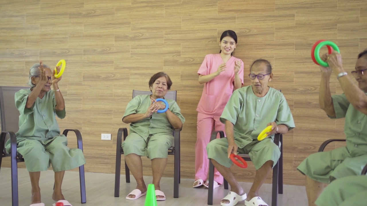 一群快乐的亚洲老人或老人与护士在养老院玩游戏的肖像。老年人生活方式活动娱乐。退休社区。卫生保健视频素材