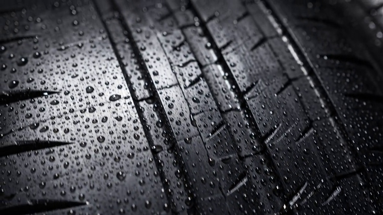 胎面图案与水滴在一个崭新的旋转街道轮胎视频素材
