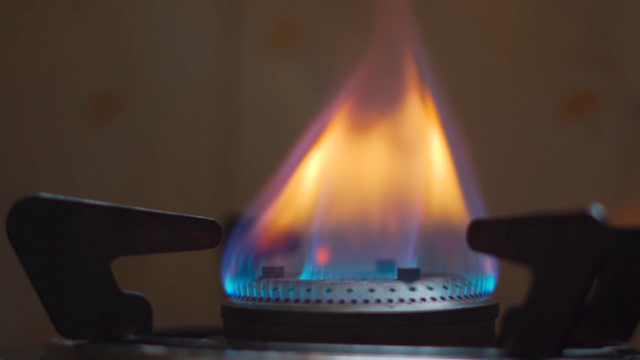 燃气灶的特写镜头打火机点燃炉子，蓝色的烹饪火焰。天然气炎症，闭合。印度女性在厨房点燃炉子做饭视频素材