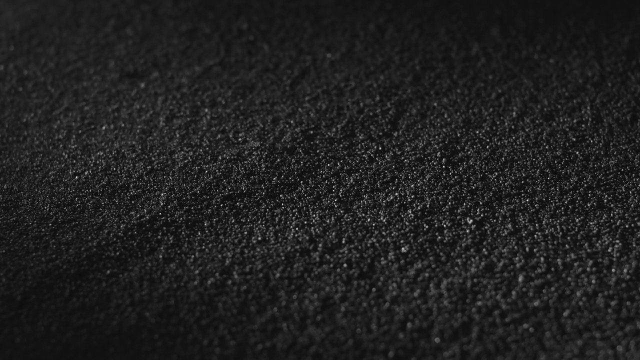碳粉或黑炭粉。黑暗的背景纹理。火山尘埃在地表移动，特写视频下载