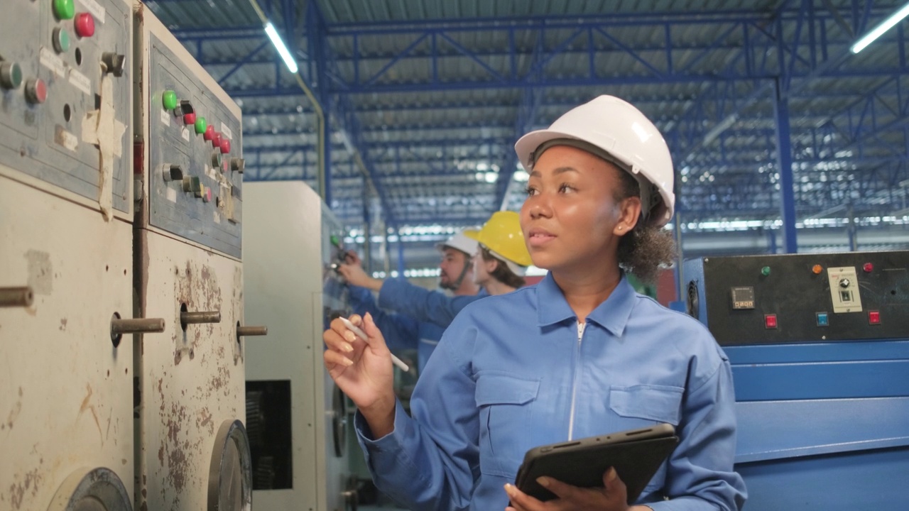 女工程师在制造工厂检查机器控制面板。视频素材