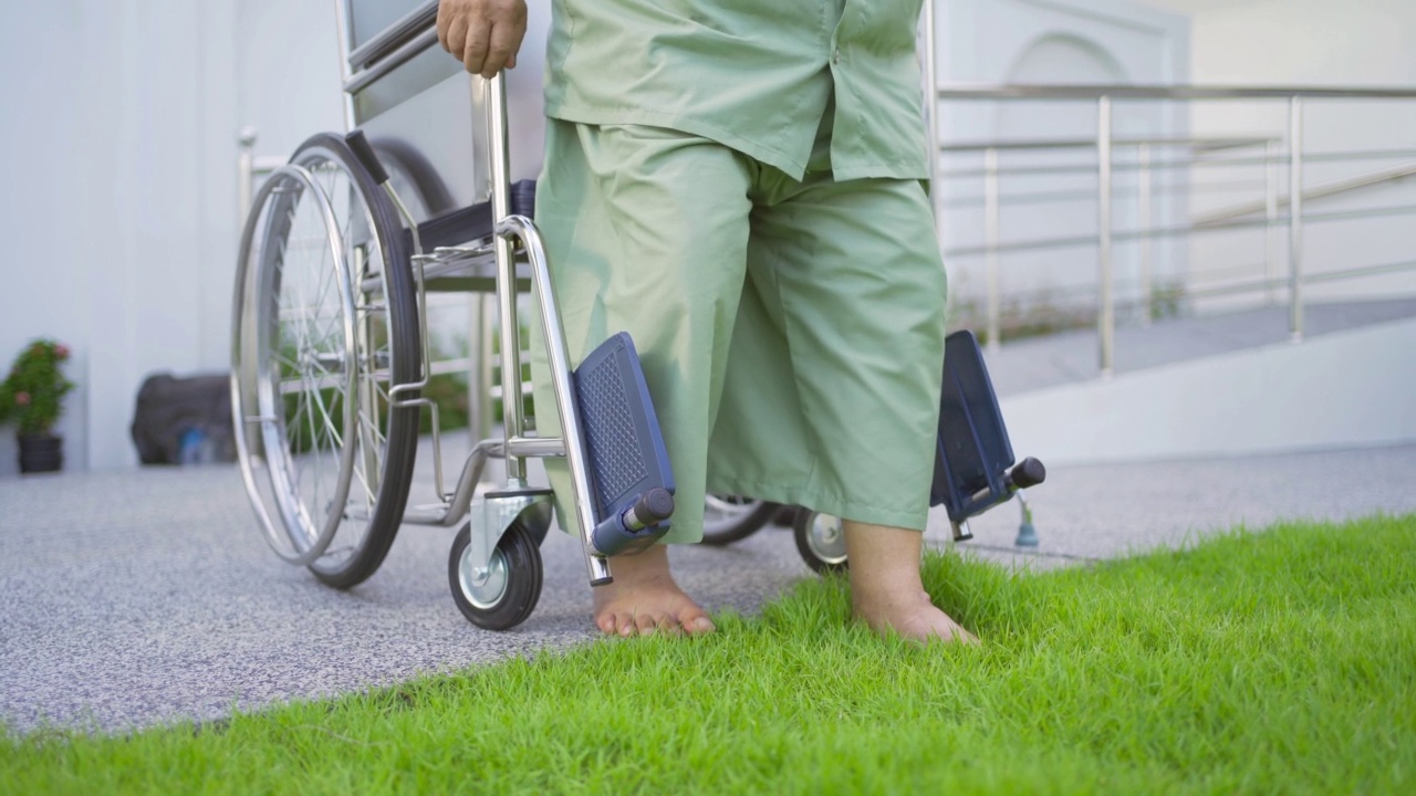 年迈的亚洲残疾病人或养恤金领取者和医生使用轮椅在医院的养老院练习行走。老年人生活方式、活动、娱乐。保健理疗视频素材
