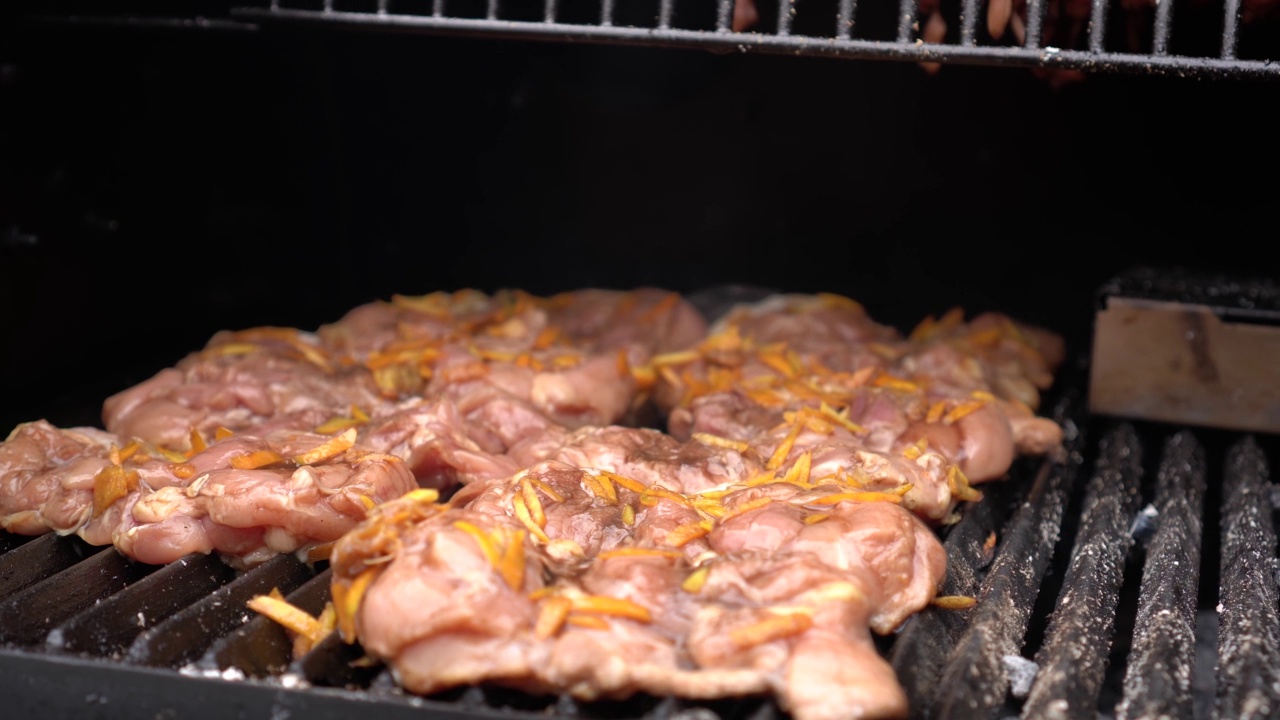 户外烧烤的烤架盖打开，露出鸡肉片在烤架格栅上烹饪视频素材