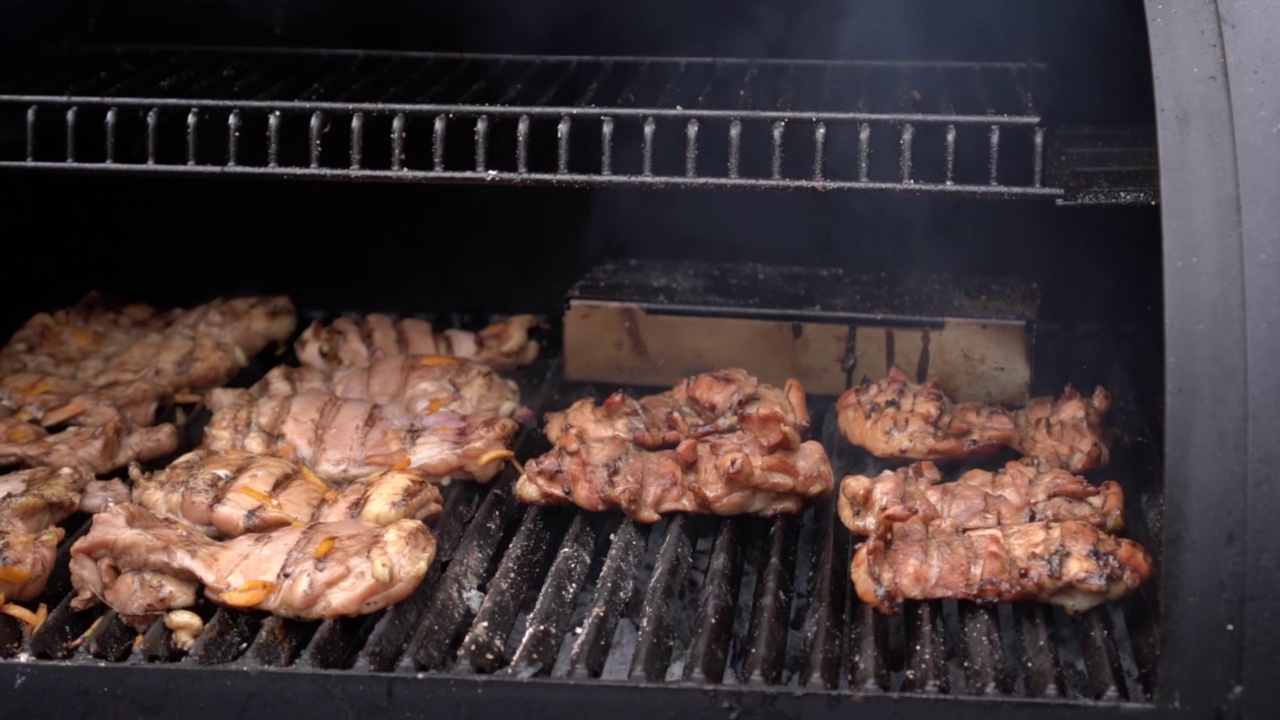 户外烧烤的烤架盖打开显示热鸡肉和牛排在烤架格栅烹饪视频素材