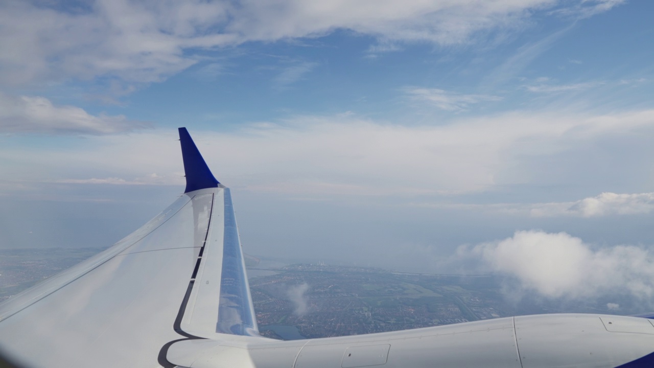 通过飞机机翼，引擎和经过的云的飞机窗口查看视频素材