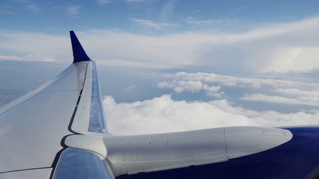 通过飞机机翼，引擎和经过的云的飞机窗口查看视频素材