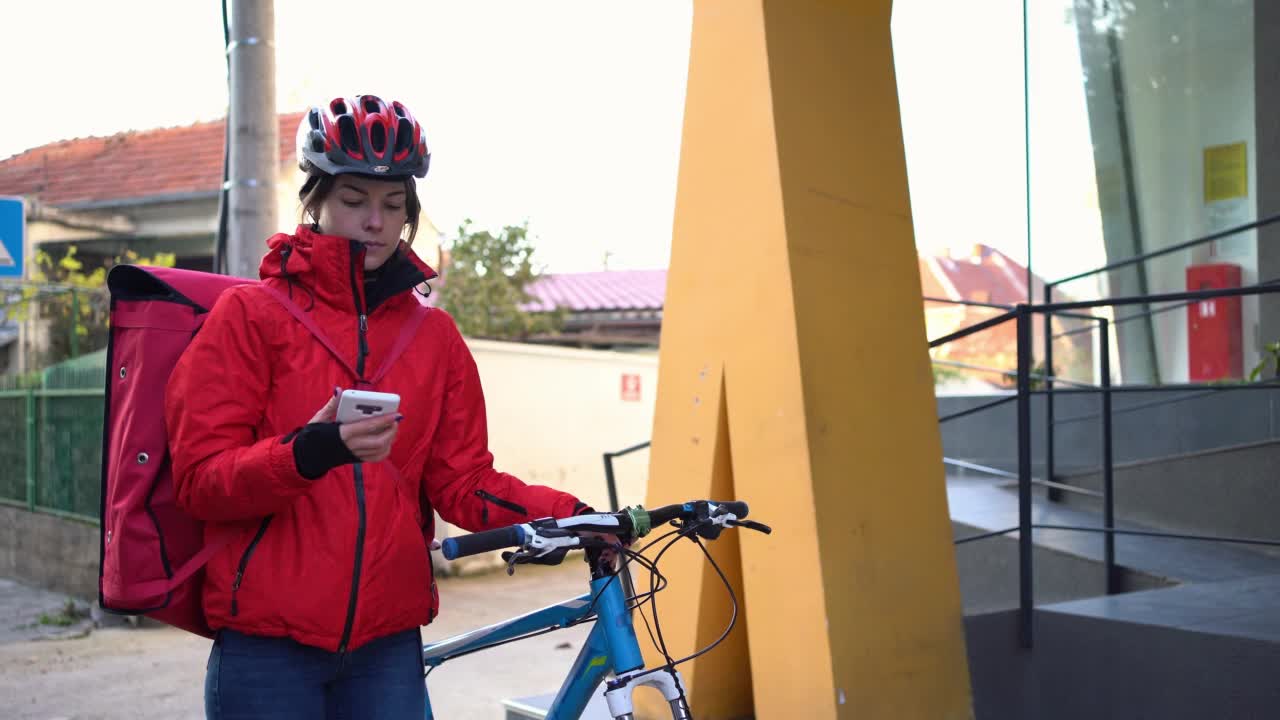 骑着自行车的快递员正在检查地址视频下载