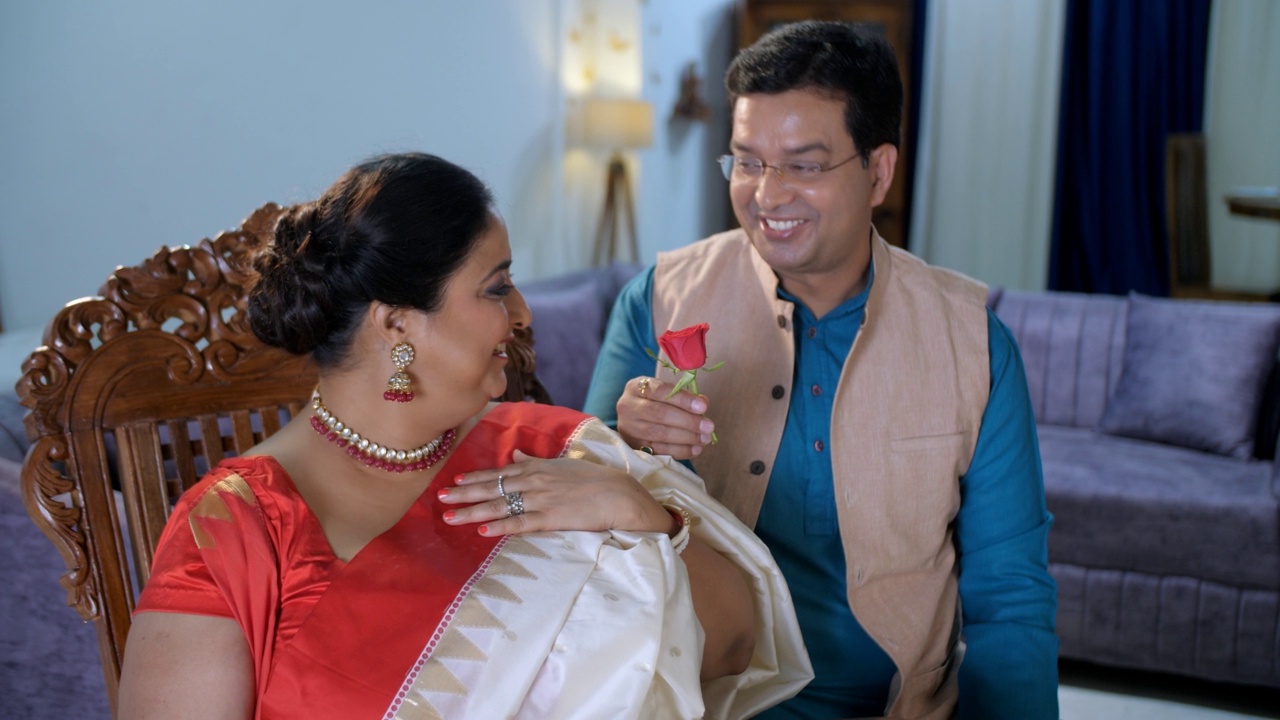 一对中年英俊的孟加拉夫妇浪漫——把一朵玫瑰放在妻子的头发上，浪漫的情侣，节日的气氛视频素材