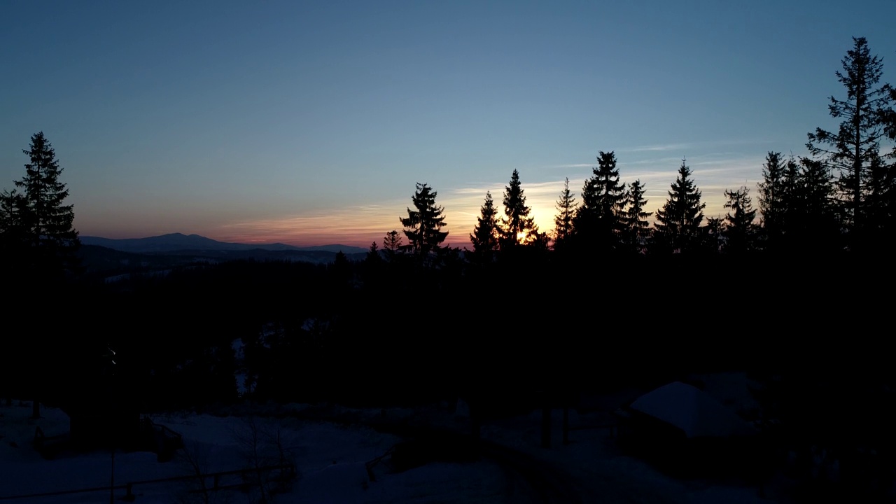在日落的冬季山上的鸟瞰图视频下载