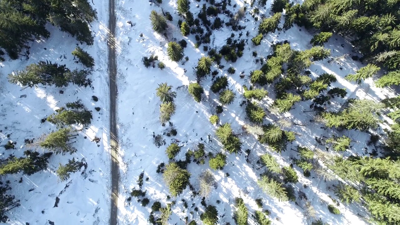雪地森林里的冬日乡村公路，无人机4k航拍。视频下载