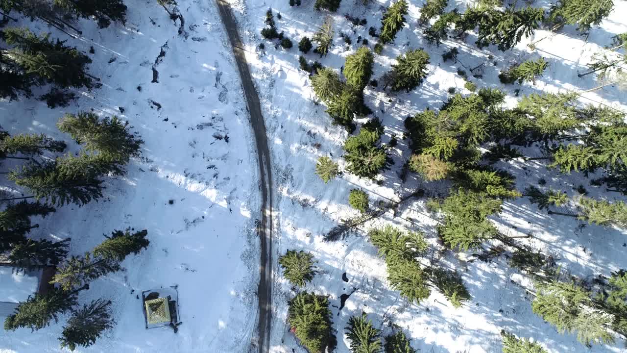 雪地森林里的冬日乡村公路，无人机4k航拍。视频下载