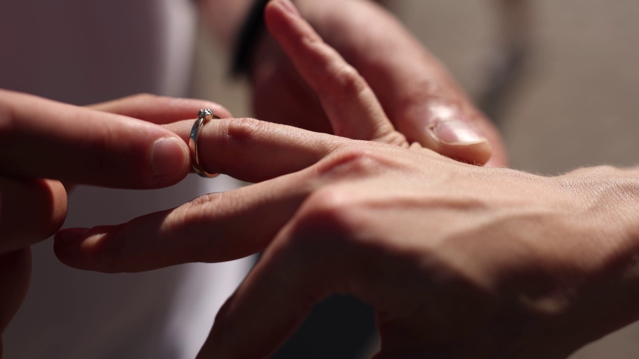 男人把结婚金戒指戴在女人的手指上视频素材