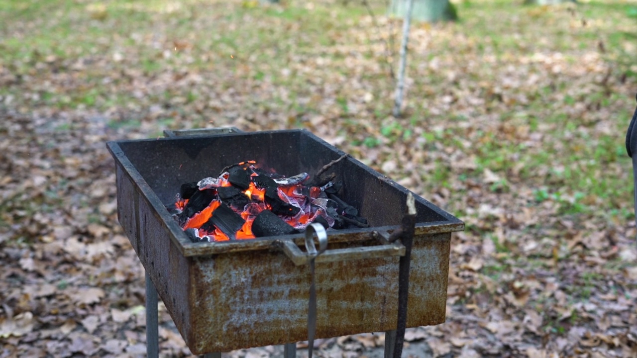 用锅铲点火，用燃烧的炭火点燃火盆做烧烤视频素材